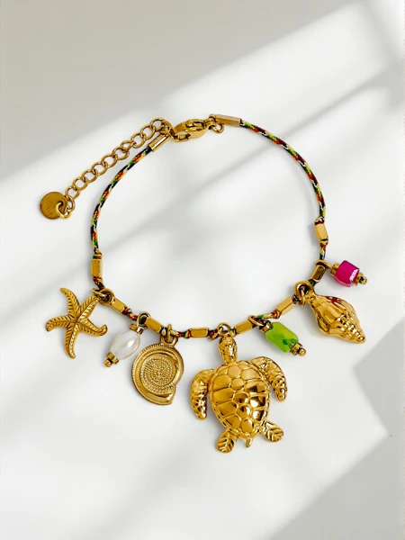 Aphrodite Maretta aranyozott karkötő tengeri bűbájokkal és gyöngyökkel
